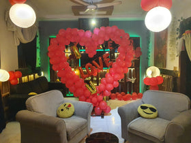 Anniversary lounge decoration Karachi with giant red heart balloon arch and LOVE U letters – image 1