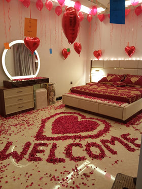 Anniversary room decoration Karachi with rose petal welcome heart, red heart balloons and fairy lights – image 1
