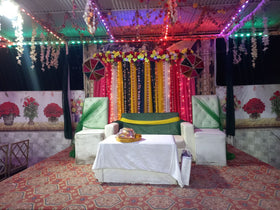 Outdoor mehndi stage decoration Karachi with colourful curtains umbrellas and lights – image 1