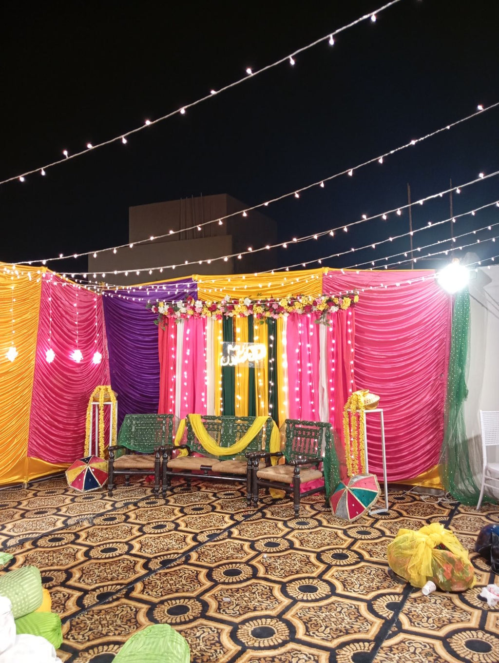 Rooftop dholki decoration Karachi with colourful curtain backdrop and fairy light canopy – image 3