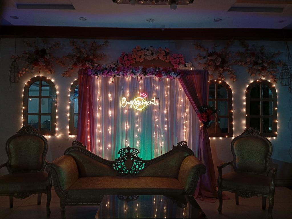 Engagement neon sign with ring on draped curtain backdrop with fairy lights - nikkah decoration package