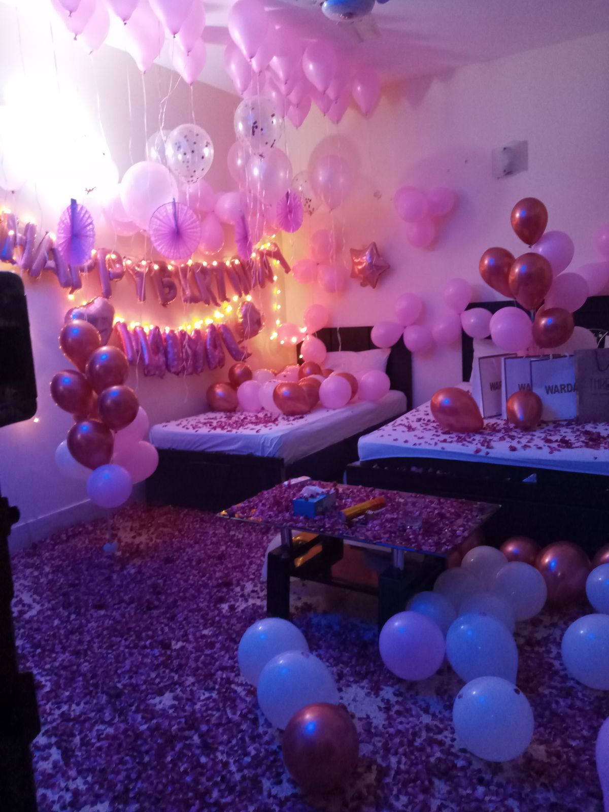Pink and rose gold surprise birthday anniversary room decoration Karachi with balloons and rose petals – image 1