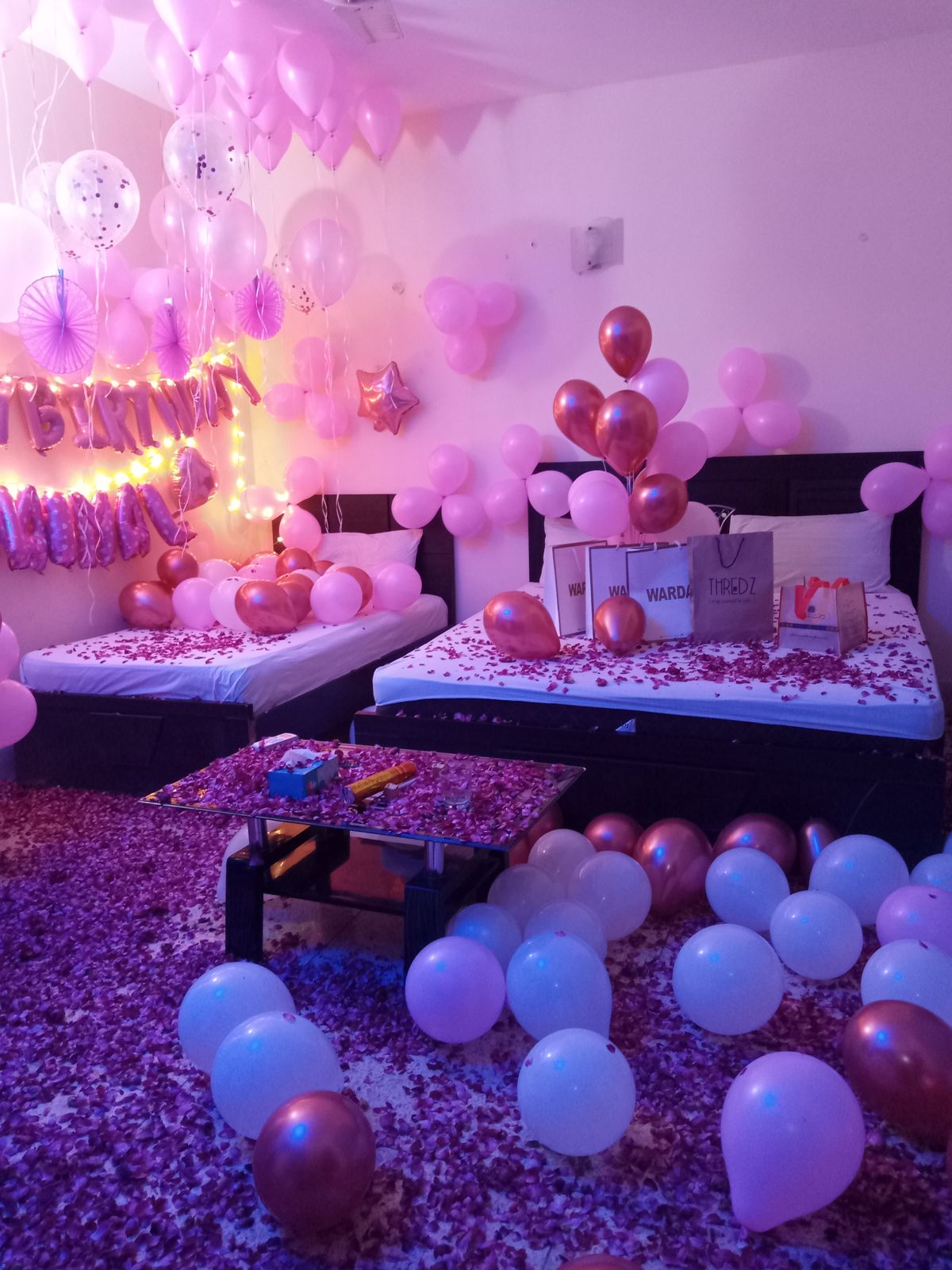 Pink and rose gold surprise birthday anniversary room decoration Karachi with balloons and rose petals – image 2
