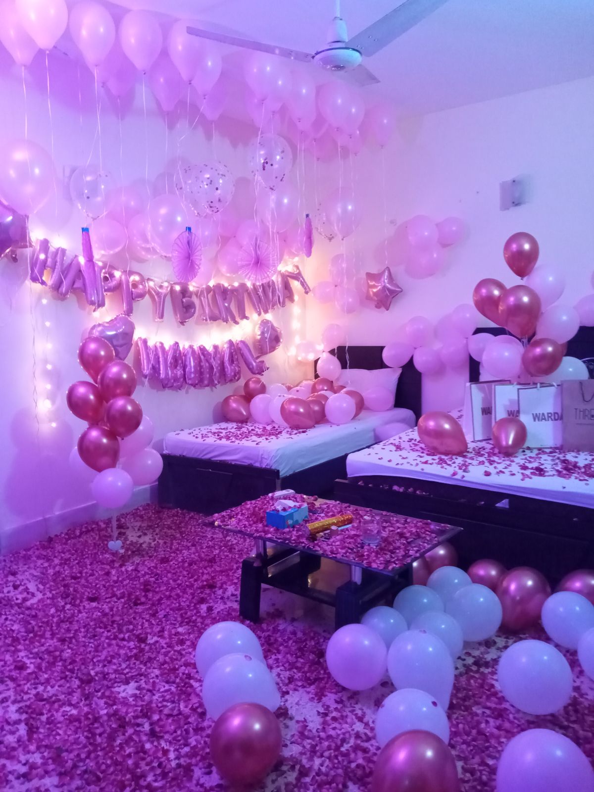 Pink and rose gold surprise birthday anniversary room decoration Karachi with balloons and rose petals – image 3