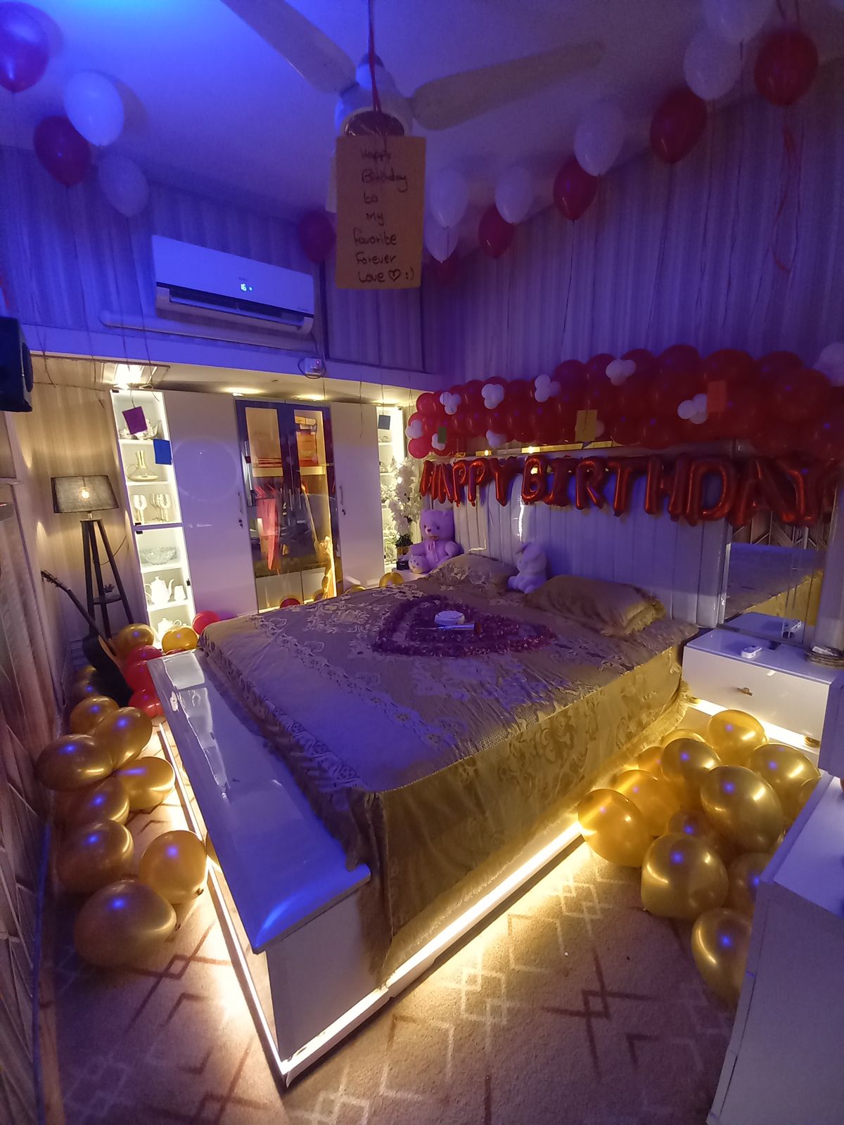 Romantic birthday bedroom decoration Karachi with red white balloons and rose petal heart on bed – image 2