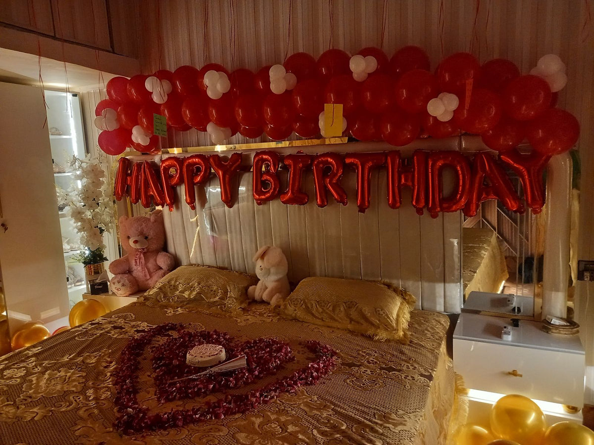 Romantic birthday bedroom decoration Karachi with red white balloons and rose petal heart on bed – image 4