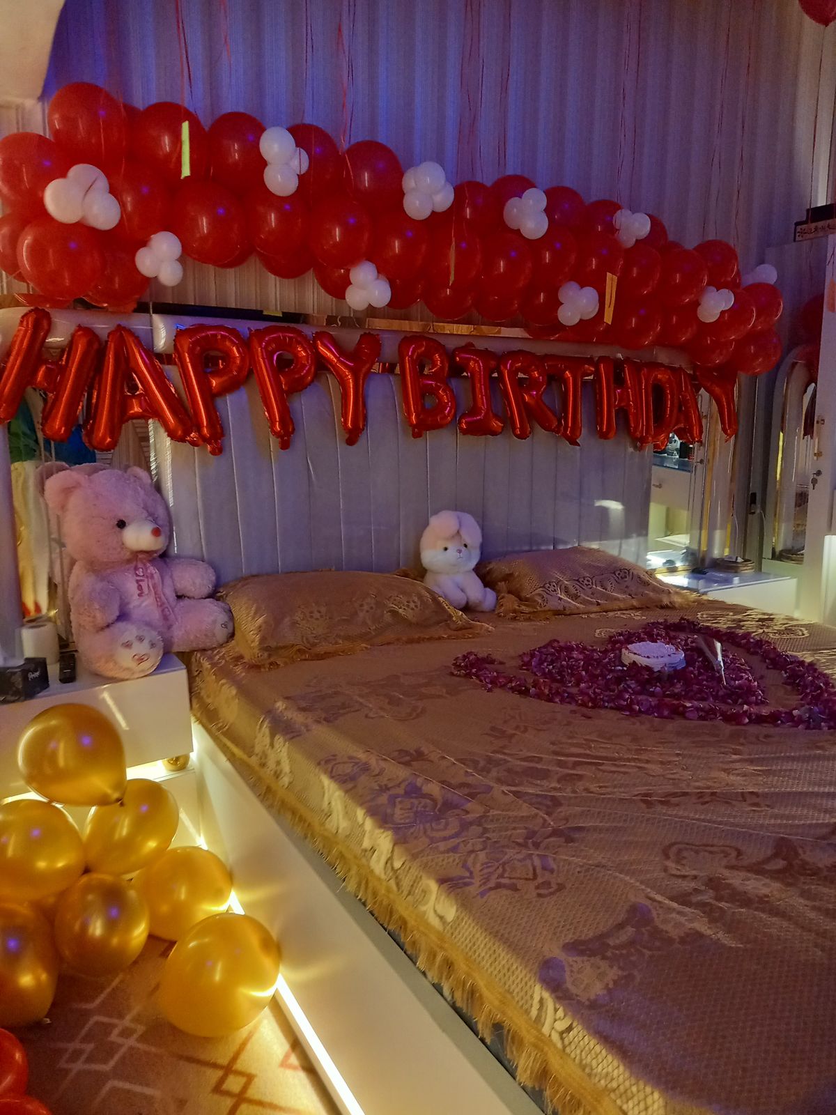 Romantic birthday bedroom decoration Karachi with red white balloons and rose petal heart on bed – image 5