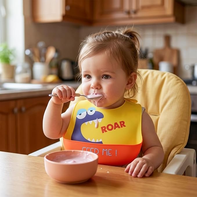 Toddler eating wearing yellow silicone bib